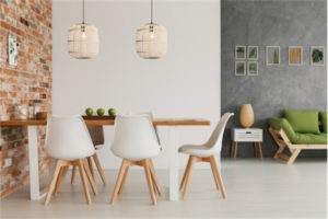 Luminaire suspendu moderne BORDESLEY Eglo 43231A au-dessus de la table en bois avec chaises blanches et mur de brique.