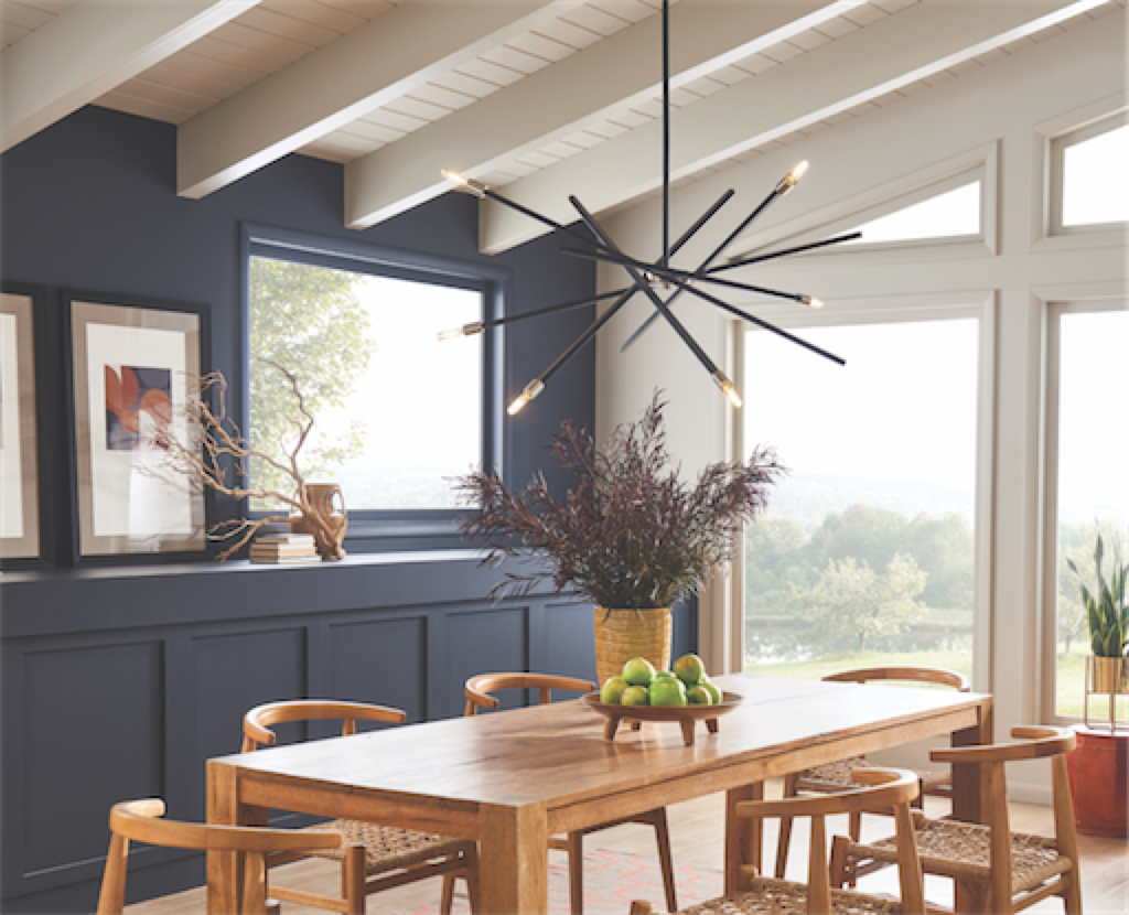 Luminaire suspendu moderne ARCHER Hinkley 4765SK dans la cuisine au-dessus de la table en bois avec mur bleu et grandes fenêtres