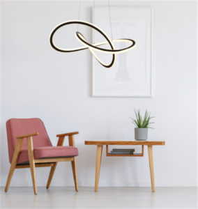 Luminaire suspendu moderne ZOLA Canarm LCW155A21BK au-dessus d'un fauteuil en bois avec coussin rose et table d'appoint en bois.