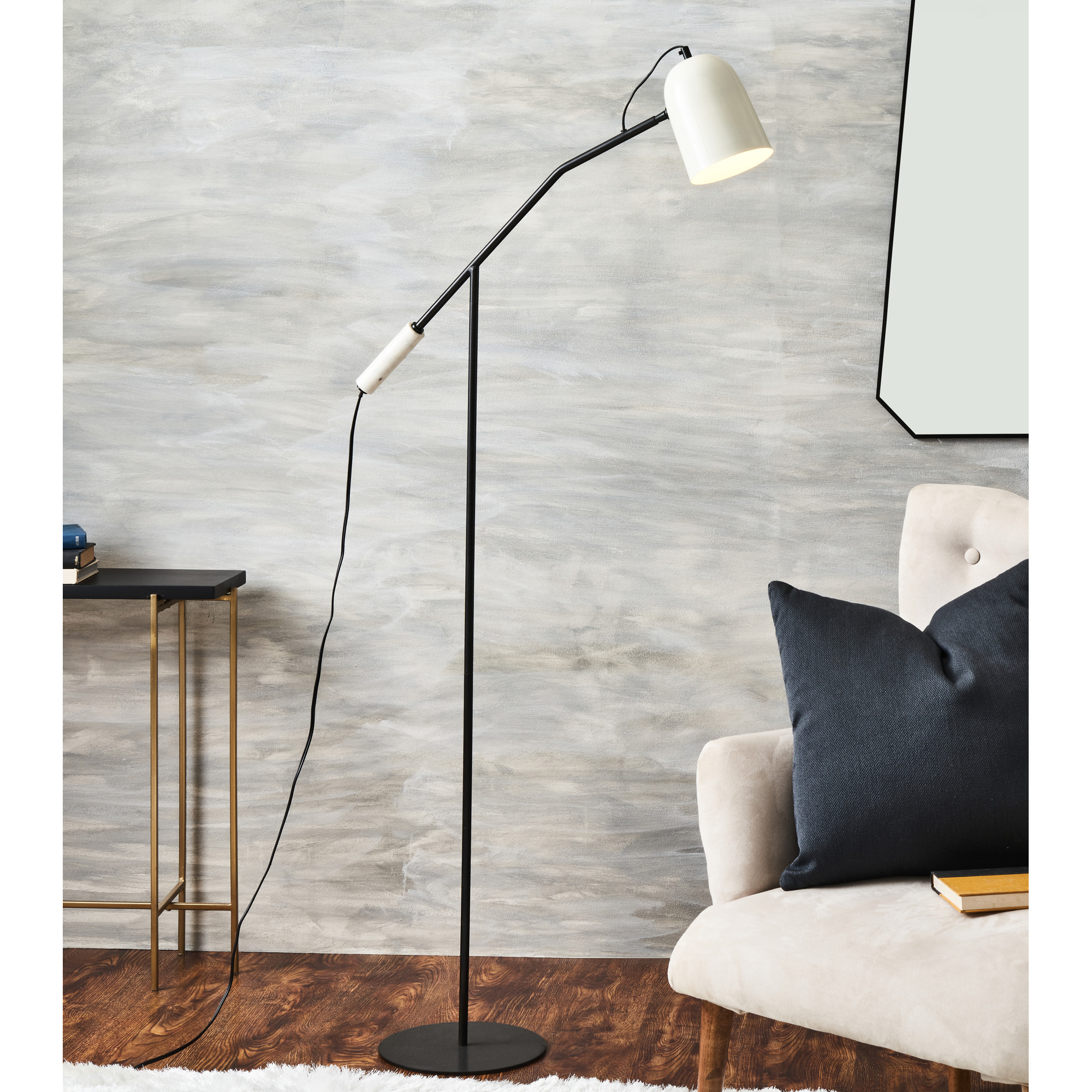 Lampe de plancher OSTERBERG Renwil LPF3121 noir et blanche près du fauteuil avec coussins